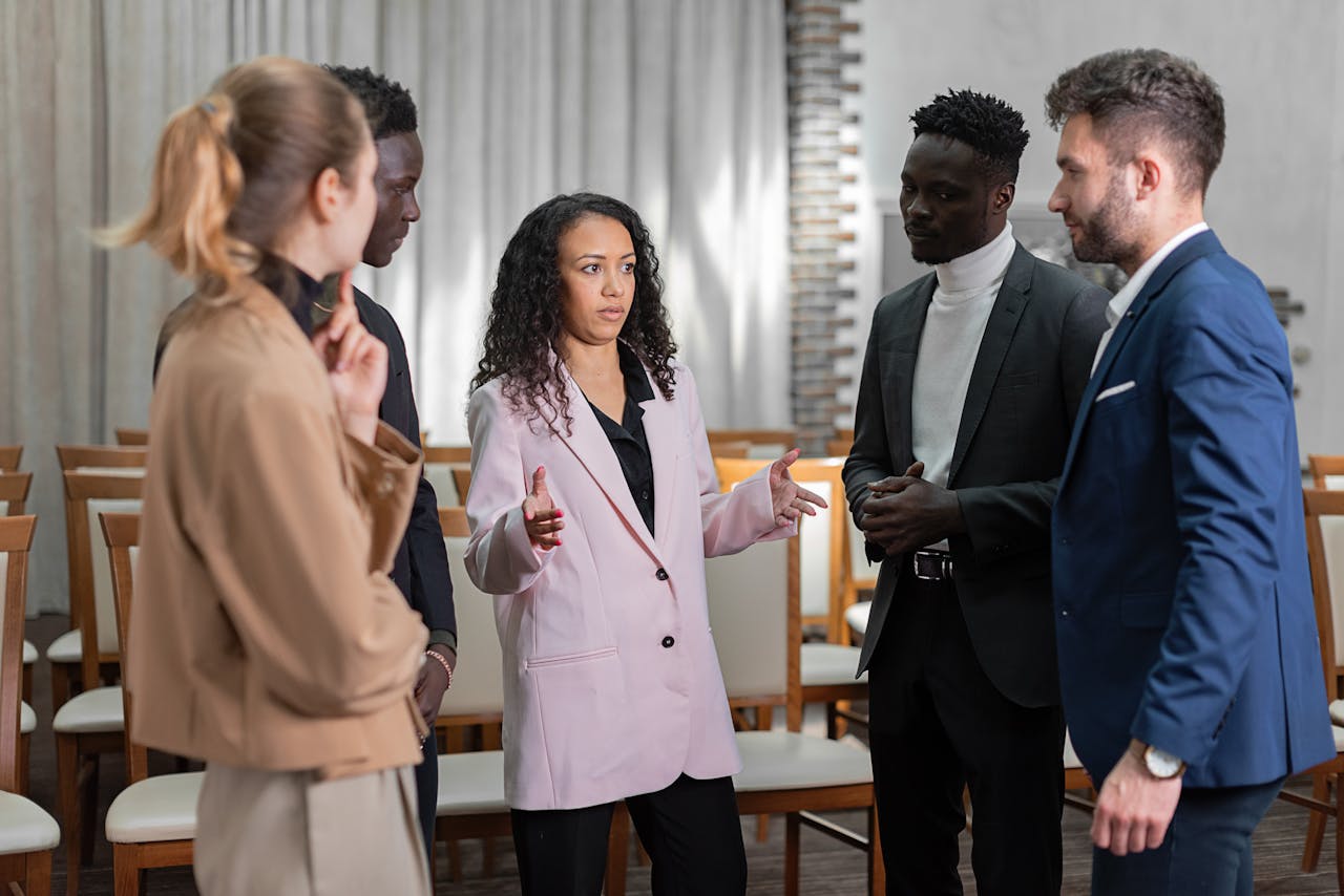 Group of well-dressed professionals having a focused conversation indoors.